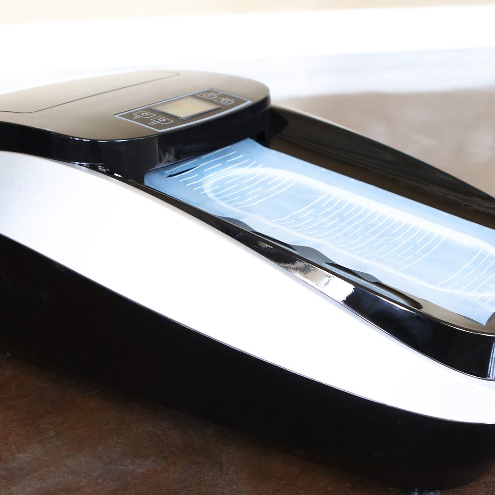 SoleMate SM-76C automatic shoe cover dispenser applying a hands-free shoe cover